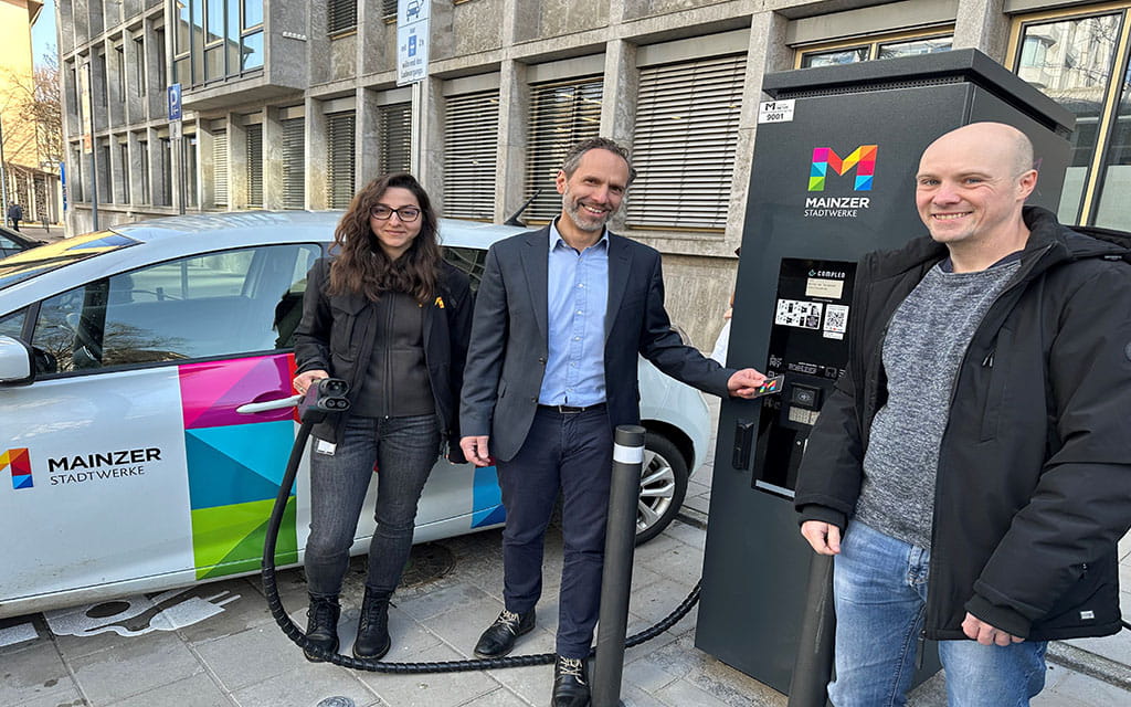 Drei Menschen an einer Ladesaeule für E-Autos von den Mainzer Stadtwerken